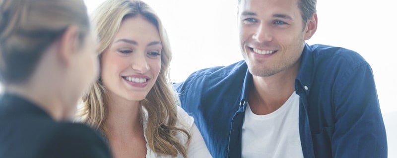 un couple signant un contrat d'assurance prêt immobilier investissement locatif